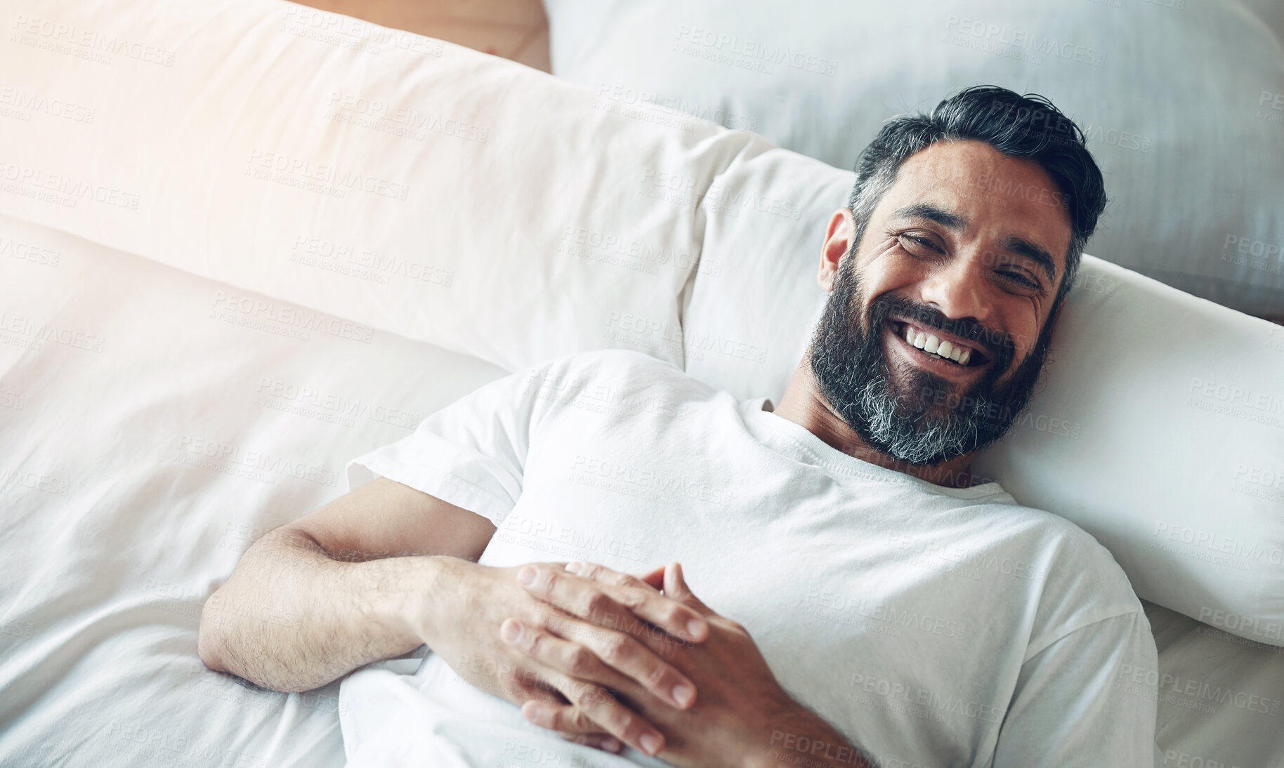 Buy stock photo Top view, portrait and man on his bed, relax and smile on a break, chilling and cheerful at home. Face, male person and happy guy in his bedroom, resting and wellness with joy, happiness and morning