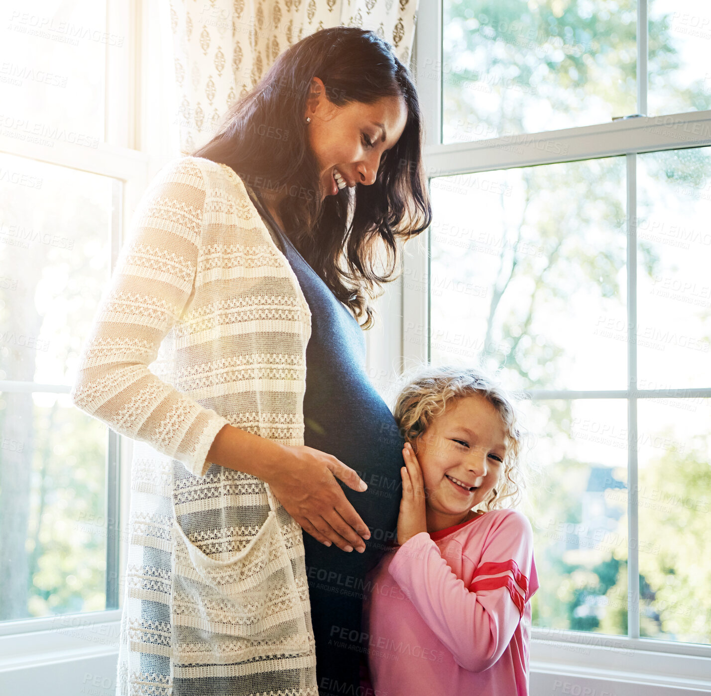 Buy stock photo Pregnant, mother and daughter with listening to stomach for baby kick, excited for newborn and curious with smile in home. Woman, pregnancy and happy child with ear on tummy for bonding, love or care