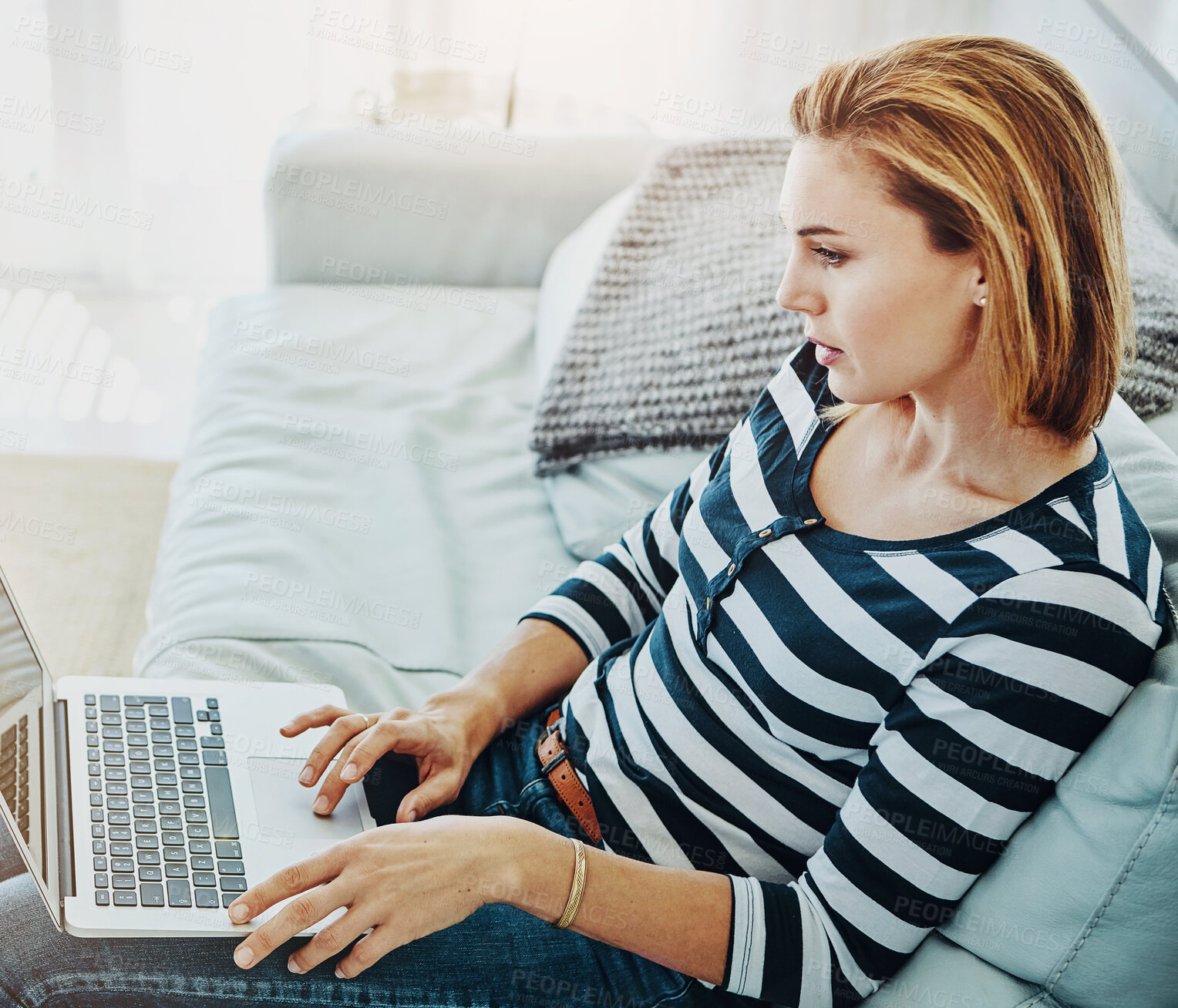 Buy stock photo Woman, laptop and home with typing for remote work in startup, career with reading on couch. Female person, graphic designer and computer with research for creative, plan for website development
