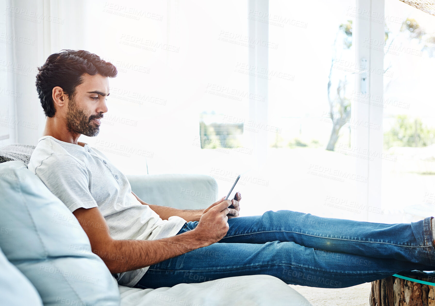 Buy stock photo Sofa, man and tablet in home or relax, scrolling and online for internet search and reading blog for streaming website. Email, social media and communication technology, comfort and weekend break