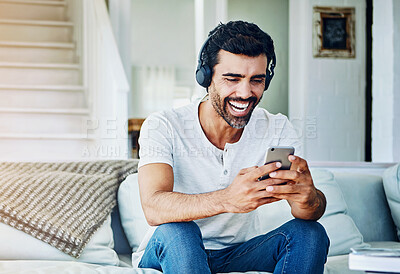 Buy stock photo Man, headphones and laughing for phone on sofa with funny social media post and comedy movie on mobile app. Person, smartphone and happy with relax for listening to audio, sound and track on couch