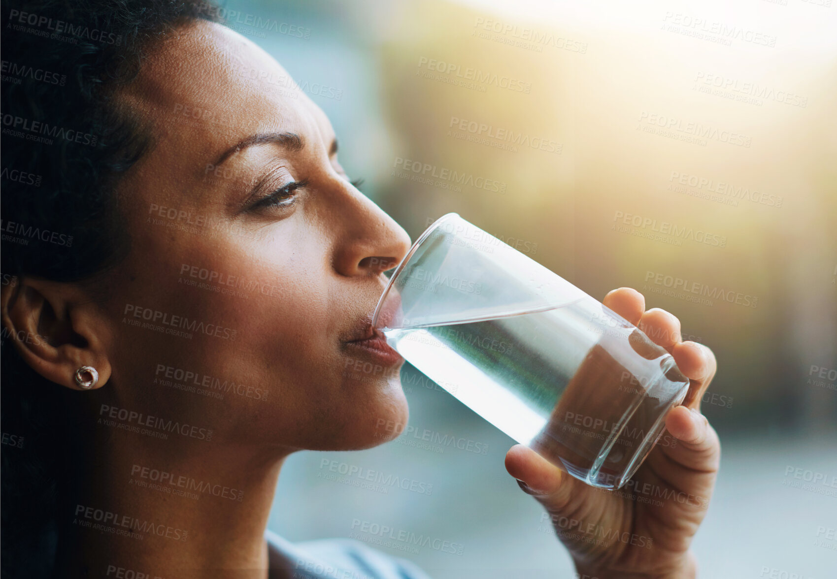 Buy stock photo Woman, thinking and home with drinking water in glass for wellness, wellbeing and hydration. Profile, female person and satisfied with self care for thirst, health and clam energy in lens flare