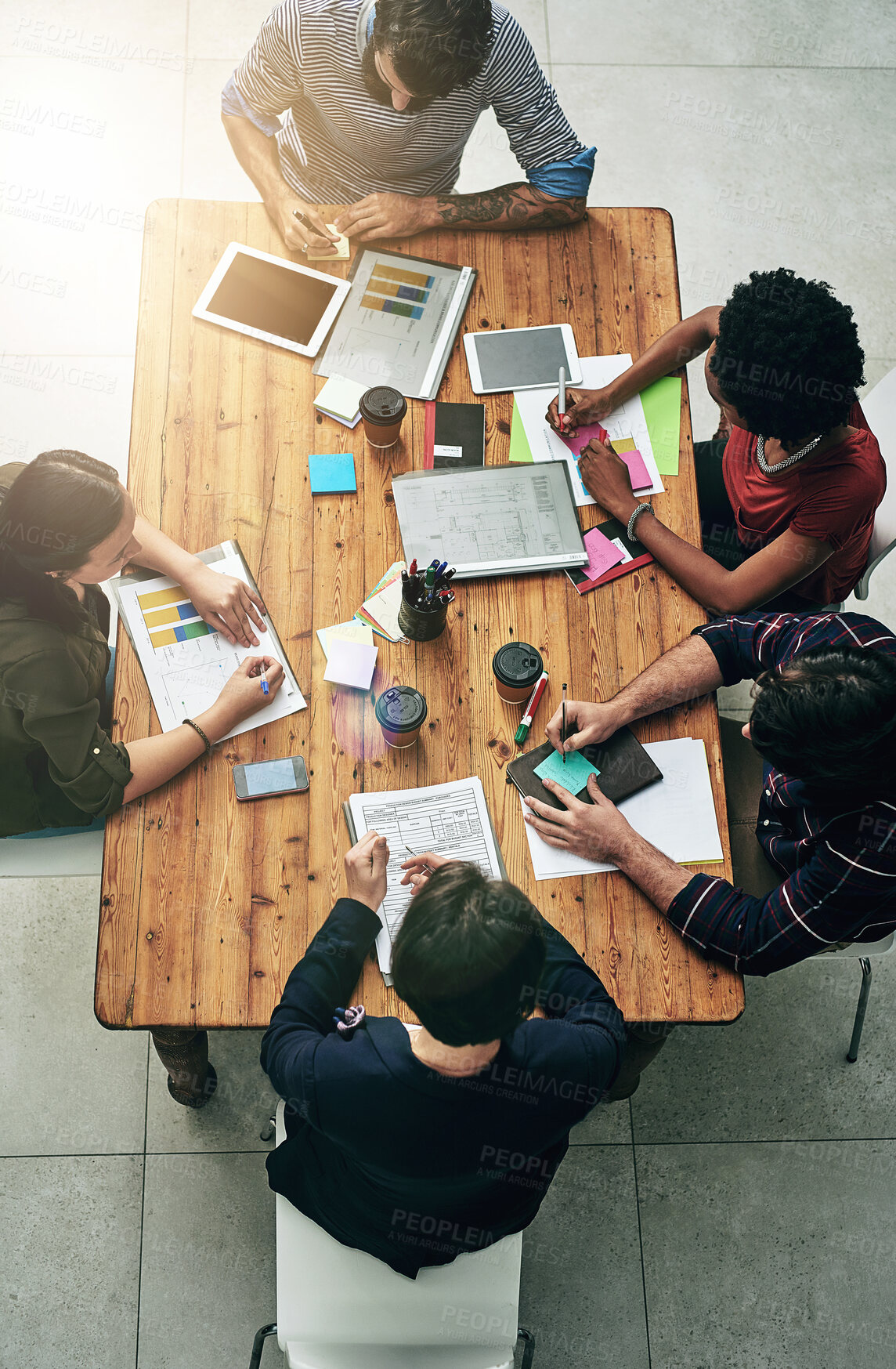 Buy stock photo Business people, discussion and documents in office for planning, subscription or company growth. Above, lens flare and diverse staff with paperwork for briefing, readership or graphs at publication