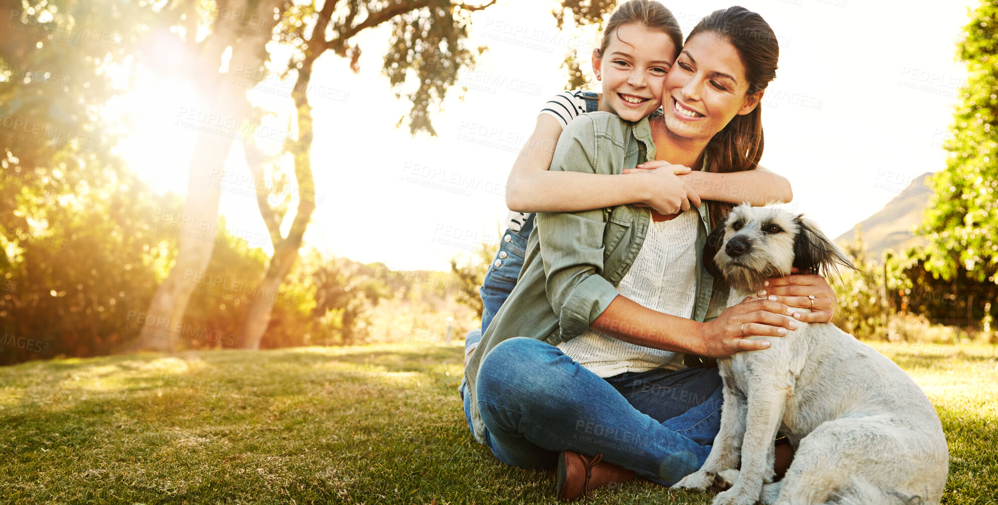 Buy stock photo Mother, daughter and playing with dog in park for bonding, relax and happy with fun activity in nature. Family, woman and girl child with puppy on grass in environment with sunlight, mockup and smile