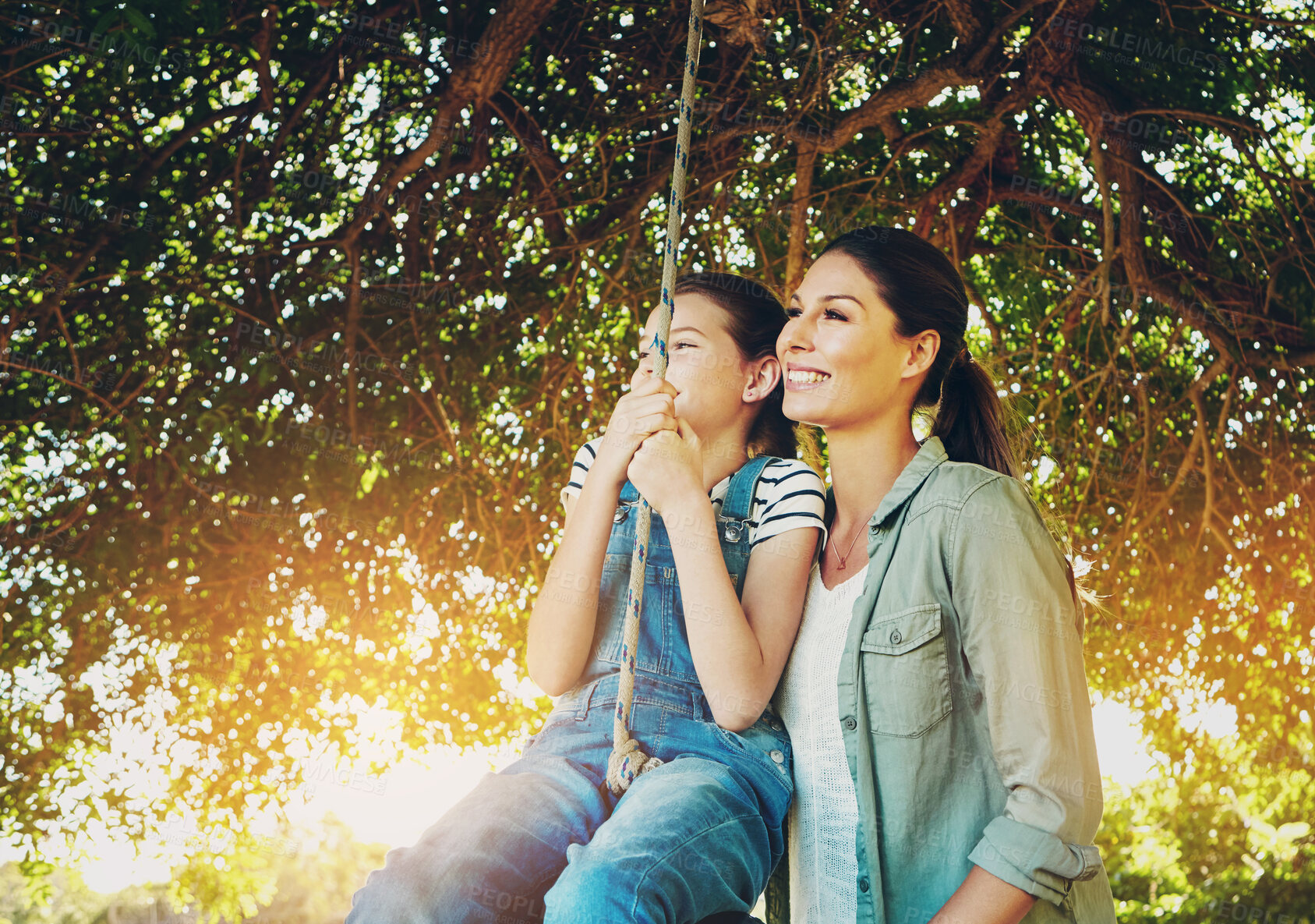 Buy stock photo Smile, mother and child on swing outdoor for bonding and kid play fun game together in nature. Happy, mom and push girl in playground at park for love, care and family connection in summer sunshine