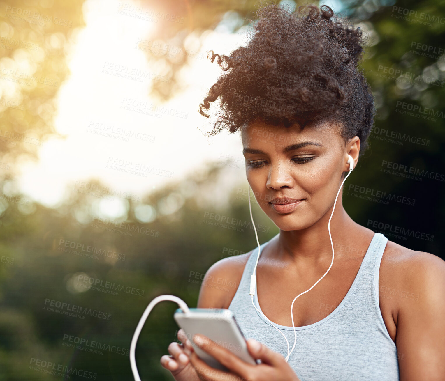 Buy stock photo Fitness, black woman and smartphone with headset for listening music, podcast and radio with smile. Nature, female runner and mobile to change audio track, song and playlist for motivation outdoor
