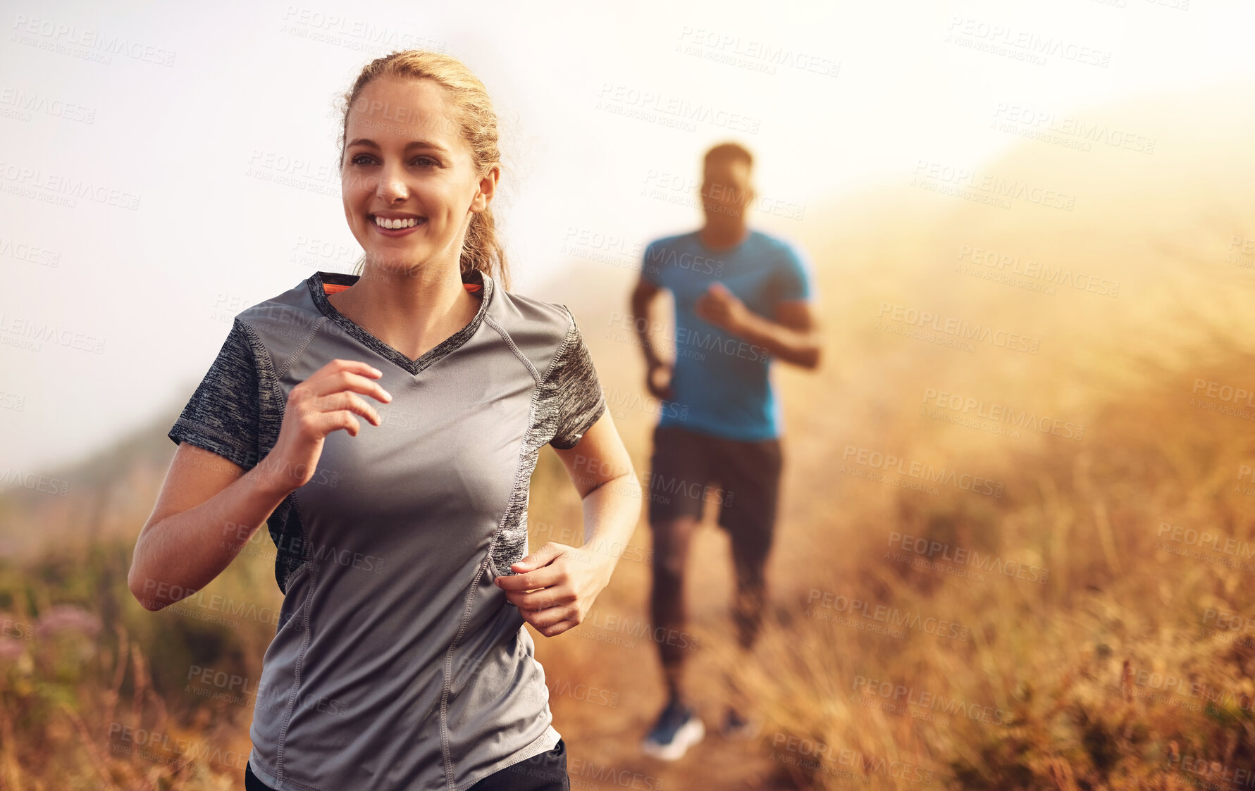 Buy stock photo Smile, woman and running for race in outdoor for marathon competition with fitness, exercise and cardio training in forest for health. People, man and athlete as runner together for challenge workout