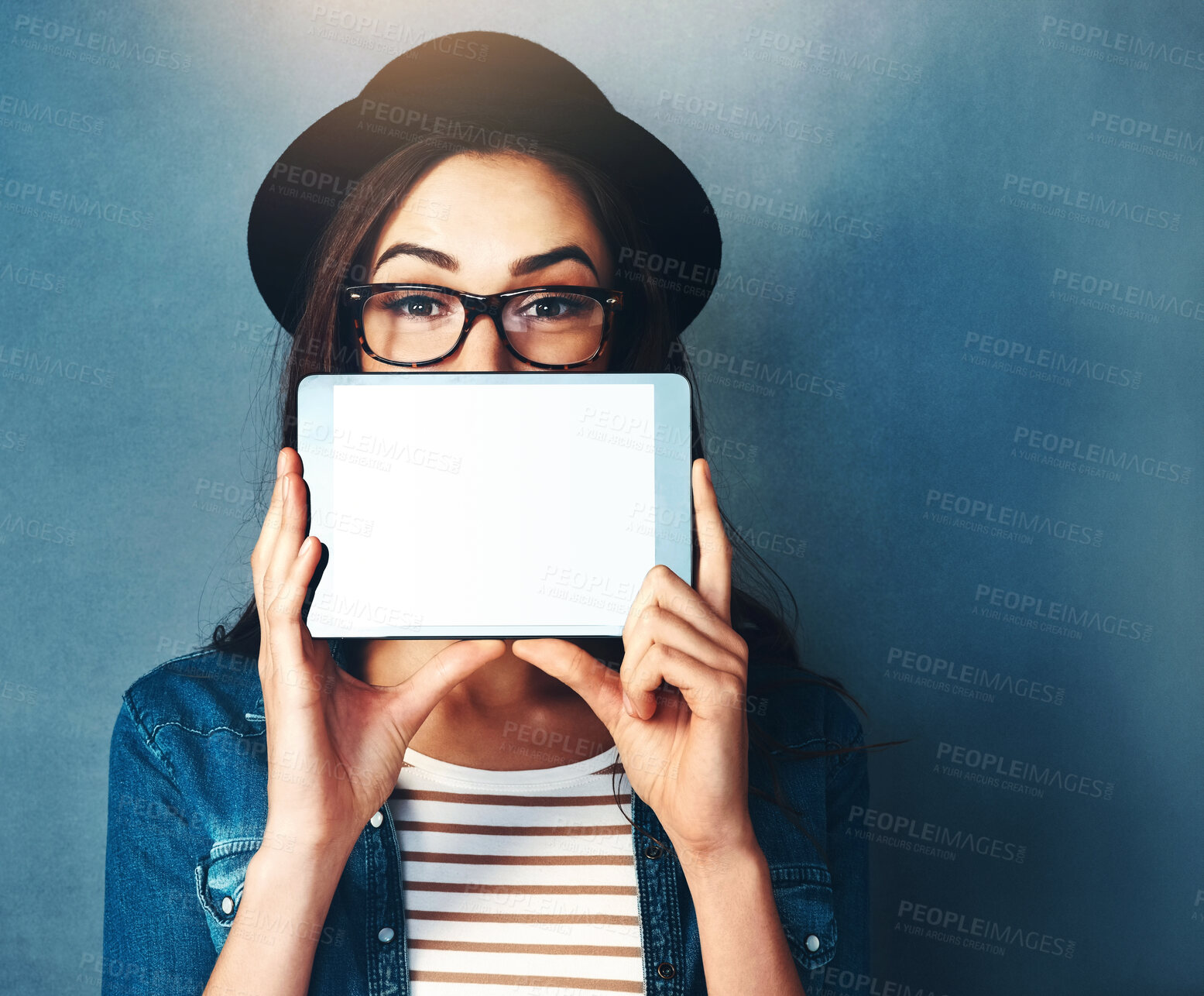 Buy stock photo Woman, studio and tablet with screen on face in portrait for announcement, news for digital platform. Female influencer, blue background and glasses for tech notification, mockup for online network