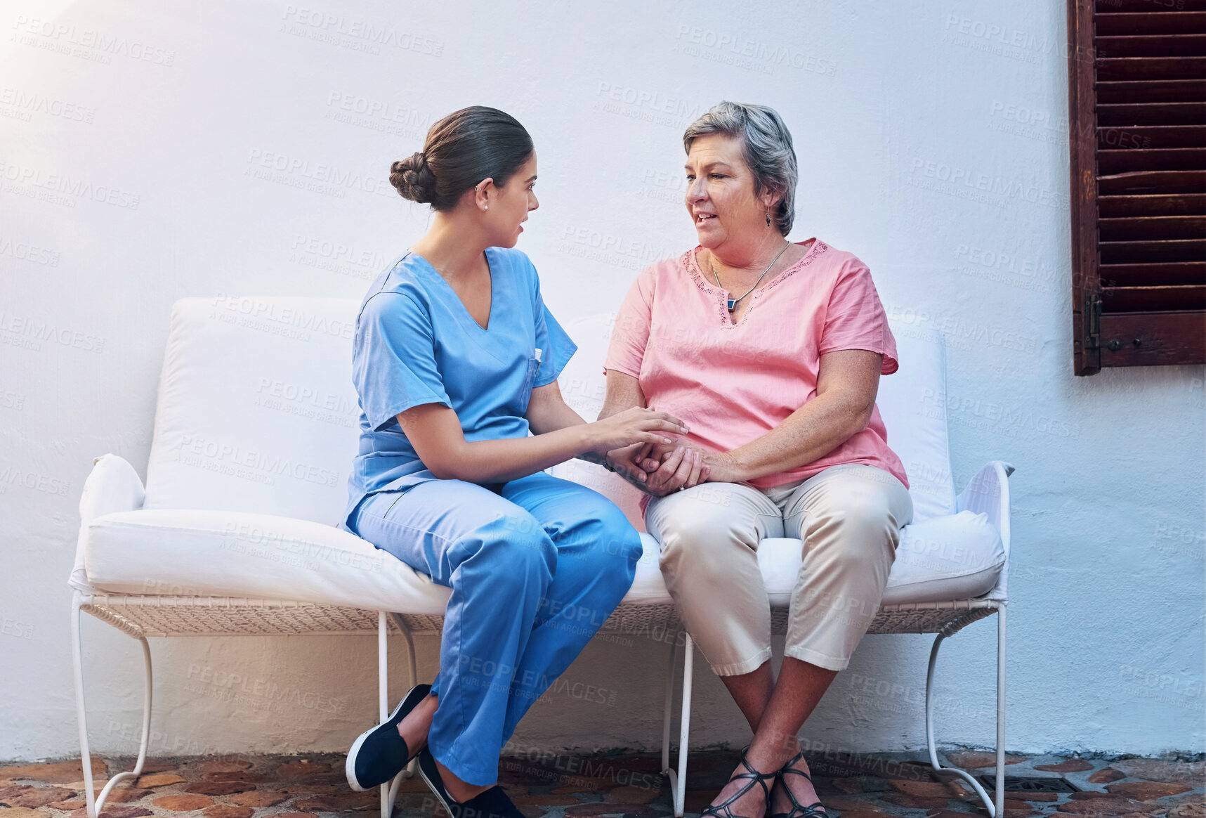 Buy stock photo Health, nurse and senior woman holding hands at retirement home for support, consulting or compassion. Help, caregiver and elderly patient on sofa for care, trust or medical conversation in outdoor