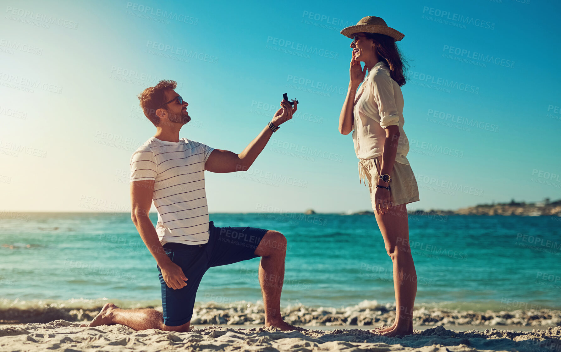 Buy stock photo Love, engagement and couple on a beach, sunshine and relationship with happiness, vacation and support. Surprise, man and woman on seaside holiday, proposal and ask for hand in marriage for romance