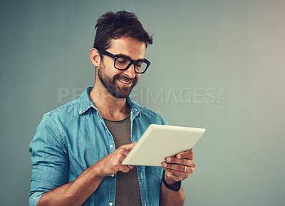 Buy stock photo Tablet, smile and studio with man online, communication and social media on gray background. Internet, online and scroll for texting on dating app, talk or happy male person on mobile for love