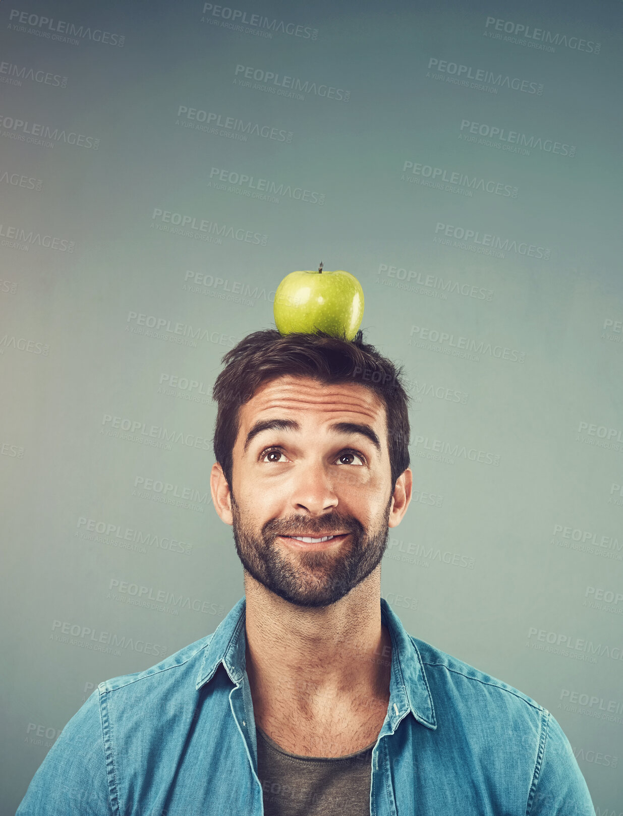 Buy stock photo Man, nutrition and balance apple on head for healthy diet, wellness and natural organic food isolated on gray studio background. Fruit, thinking and person with idea for breakfast, detox and space