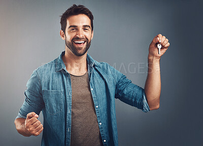 Buy stock photo Celebrate, portrait and man with key in studio for real estate, property or new home owner on gray background. Rent, tenant and excited male person for purchase, achievement or investment on mockup