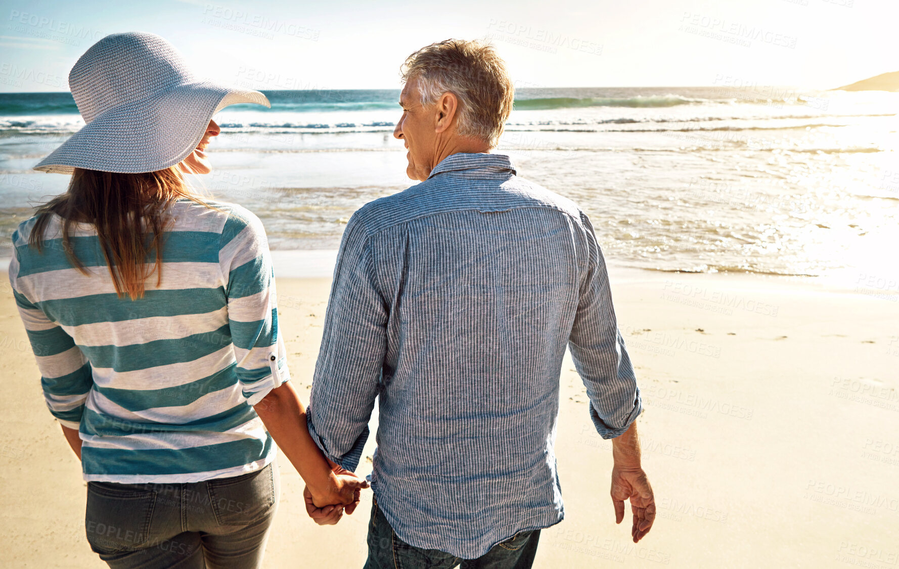 Buy stock photo Couple, beach and holding hands on vacation, travel or summer holiday for love in nature. Mature man, woman and back view at ocean for adventure, support or connection on date together outdoor at sea