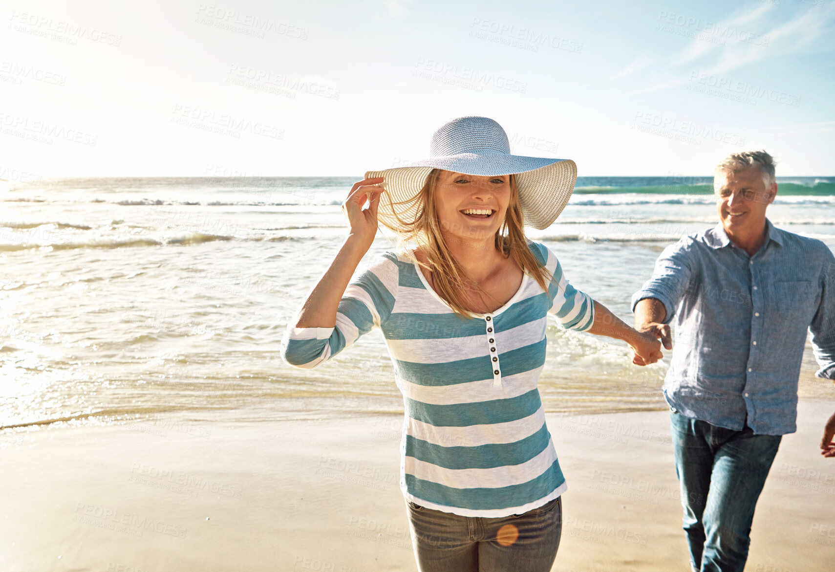 Buy stock photo Happy couple, sea and holding hands on vacation, travel or summer holiday for love in nature. Mature man, woman and walk at beach for adventure, support or laughing on date together outdoor at ocean