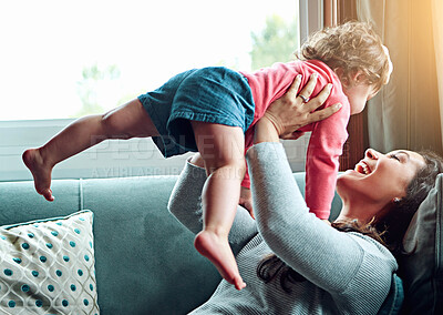 Buy stock photo Playing, mother and child flying on sofa in living room together for bonding, connection and development in home. Woman, kid or daughter airplane on couch in house for relax, fun and game with love