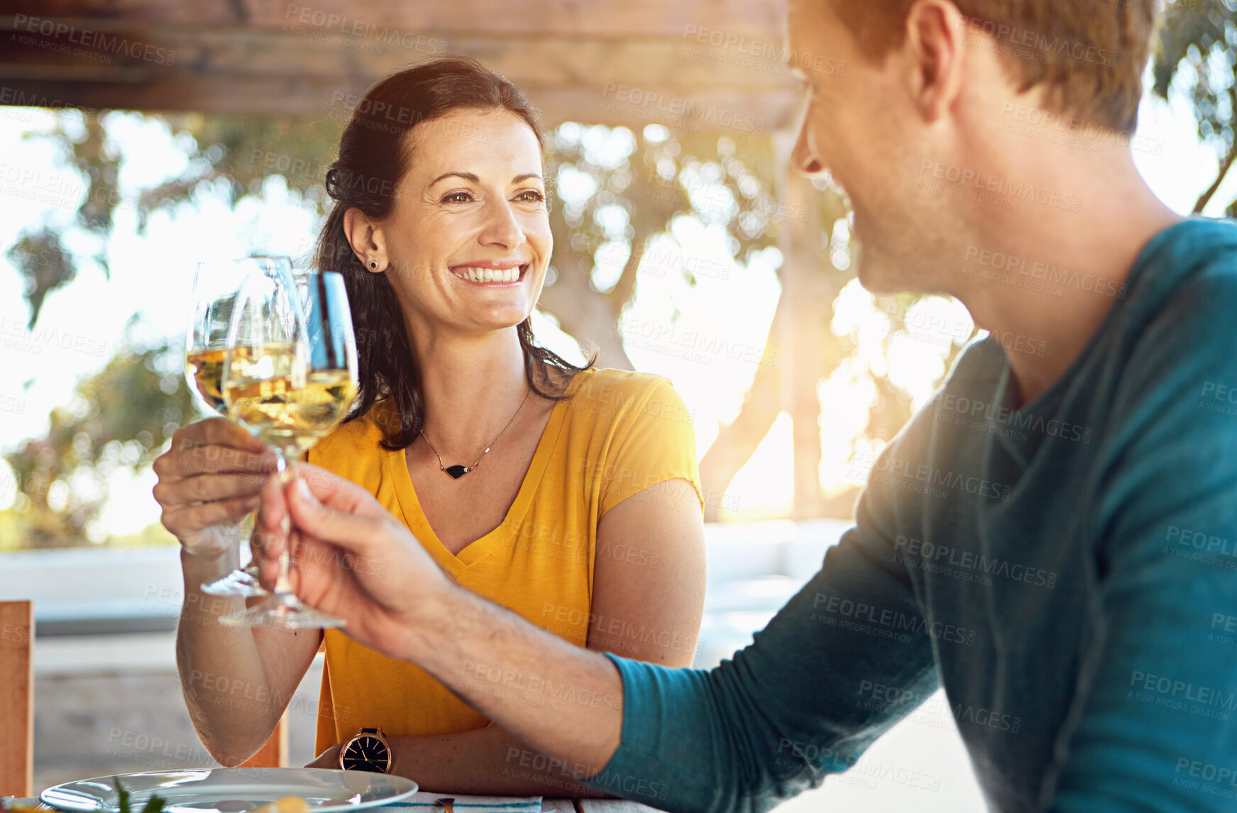 Buy stock photo Date, wine and couple with cheers on patio for celebration, lunch and romance in happy relationship. Smile, man and woman toast with glass, drinks and outdoor dinner with love, bonding and marriage.