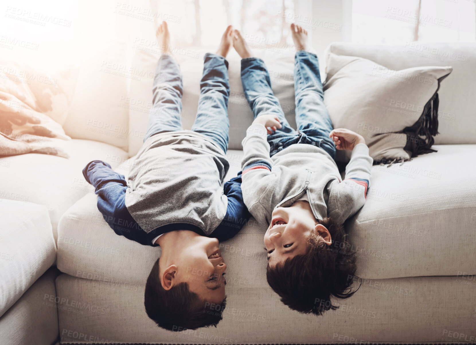 Buy stock photo Children upside down, playing and happy at family home for fun with sibling, brothers on couch and relax in living room. Kids, love and time together with cheerful boys, laughing and funny with break