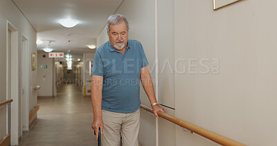 Cane, walking and senior man with disability in hospital for appointment, checkup and visit in hallway. Healthcare, corridor and male patient in clinic for help, assistance and care after injury