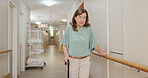 Cane, walking and senior woman with disability in hospital for appointment, checkup and visit in hallway. Healthcare, corridor and female patient in clinic for help, assistance and care after injury