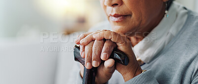 Senior woman, closeup and sad with cane for disability, healthcare and retirement in living room. Elderly person, walking stick and sigh on sofa for arthritis support, depression and mental health