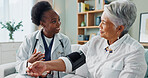 Elderly, woman and doctor with monitor for blood pressure with hypertension diagnosis, medical test and cardiovascular. Senior patient, nurse and laughing in nursing home for healthcare assessment