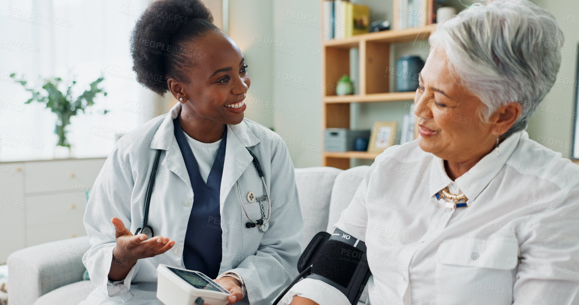 Buy stock photo Elderly, woman and doctor with monitor for blood pressure with hypertension diagnosis, medical or heart test. Senior patient, nurse and smile in nursing home for digital healthcare assessment on sofa