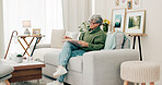 Senior woman, sofa and reading book in living room for story, novel and knowledge. Elderly female person relax with books in lounge for retirement break, literature or hobby to enjoy on couch at home