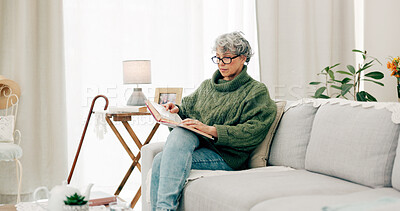 Buy stock photo Woman reading funny book in living room for story, novel and knowledge in retirement. Happy senior female person relax with books in lounge for break, literature and hobby to enjoy on sofa at home