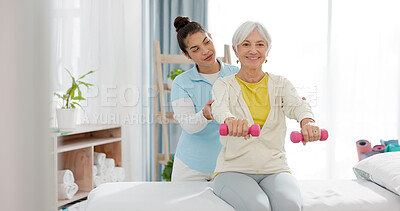 Senior woman with a dumbbell, nurse and physiotherapy in clinic for rehabilitation, fitness and support in healthcare exercise. Physical therapy, help and training with a physiotherapist in hospital