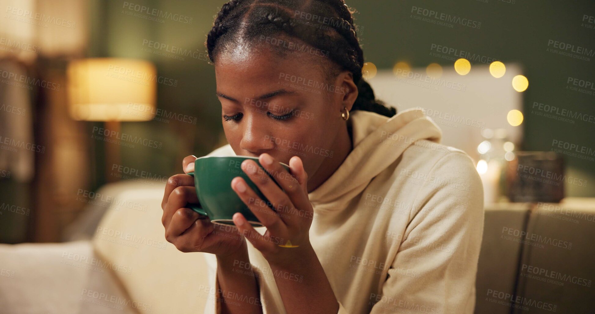 Buy stock photo African woman, tea and headache on sofa with stress, thinking or sleepless in home living room. Girl, person and frustrated for pain with chamomile drink to stop insomnia on lounge couch in apartment