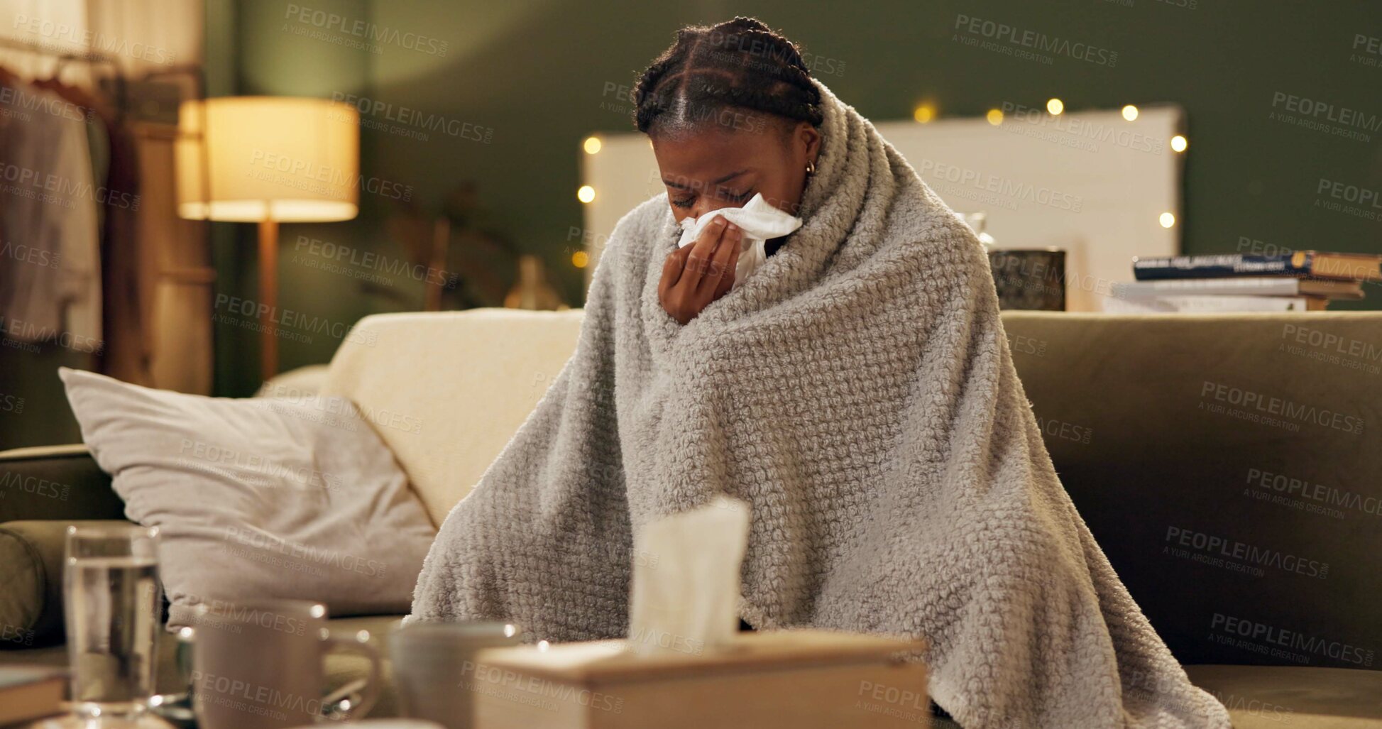 Buy stock photo Woman, cold and tissue with blanket on sofa for blowing nose, recovery or winter virus in living room. African person, infection or sick with fever, sinus and allergy on couch in home with healthcare