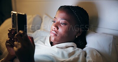 Night, typing and black woman with phone on bed for online chat, communication and networking. Resting, home and tired person on smartphone for social media, website and internet news in bedroom
