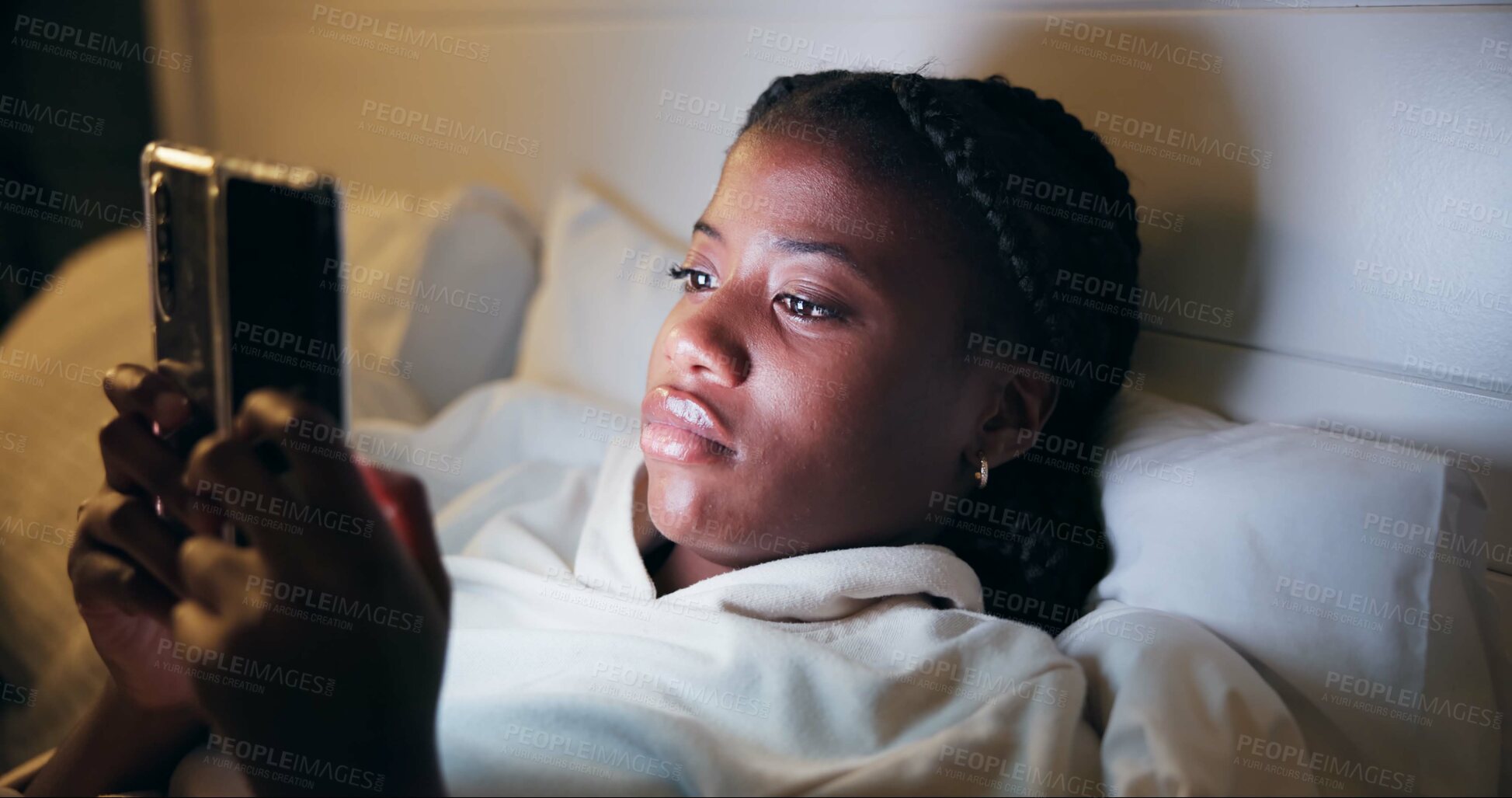 Buy stock photo Night, typing and black woman with phone on bed for online chat, communication and networking. Resting, home and tired person on smartphone for social media, website and internet news in bedroom