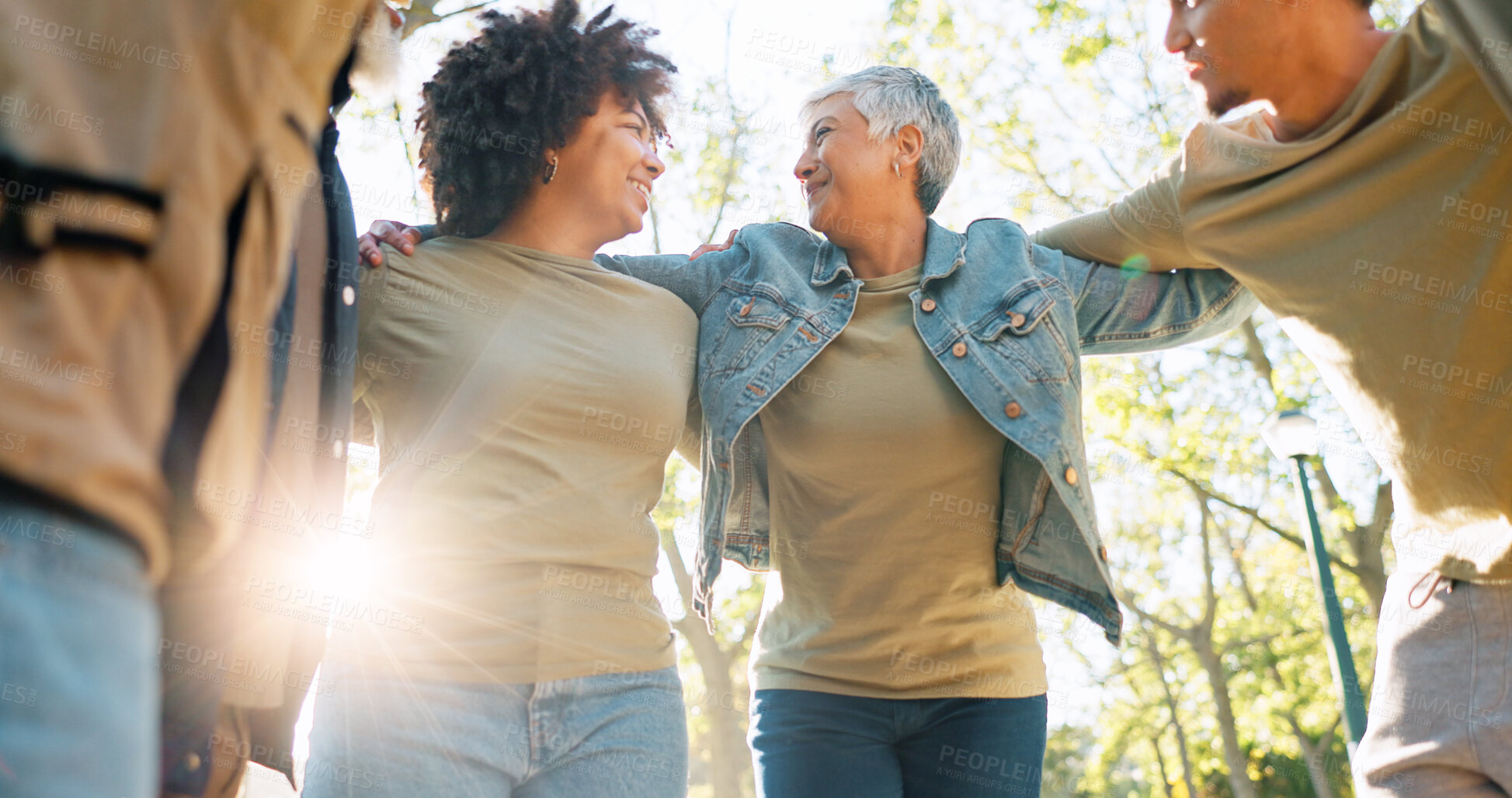 Buy stock photo Hug, volunteer and group in park, sunshine and teamwork with collaboration, lens flare and support. Charity, people and friends with nature, cooperation or embrace for motivation or clean environment