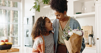 Buy stock photo Kitchen, mother and girl with smile, flowers and present for mothers day, love and family in house. Home, mom and daughter with embrace, happiness and cute in apartment, woman or child with gift