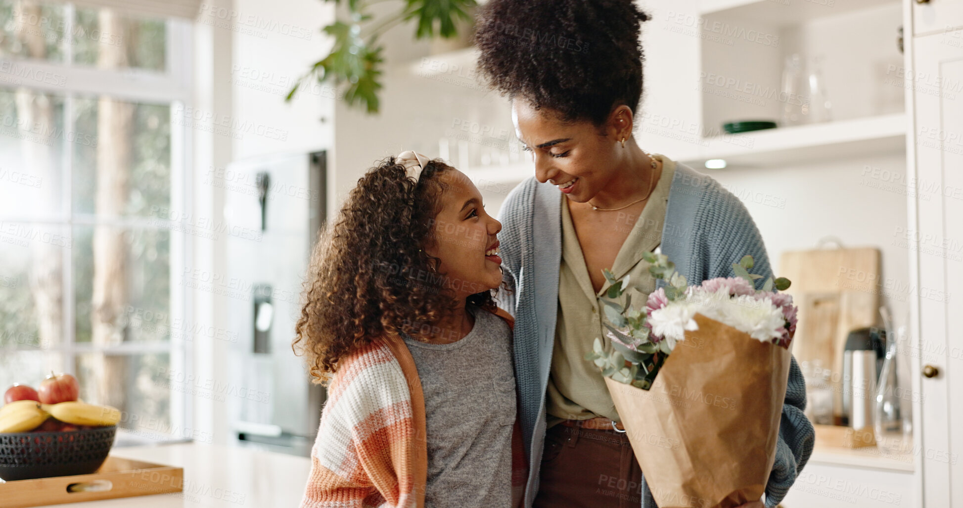 Buy stock photo Kitchen, mother and girl with smile, flowers and present for mothers day, love and family in house. Home, mom and daughter with embrace, happiness and cute in apartment, woman or child with gift