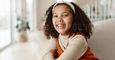Girl child, portrait and happy on sofa for relax on weekend break, rest and growth or development with positivity. Kid, face and joy or comfort on couch in living room for free time in home or house.