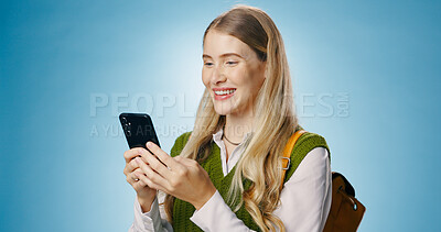 Buy stock photo Girl, phone and backpack in studio for education, learning or reading information of college results. Young person or student typing and scroll on mobile app for class schedule on blue background