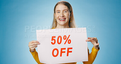 Buy stock photo Poster, sale and portrait of woman on blue background for news, announcement and information. Shopping, advertising and happy person with sign for half price discount, deal and bargain in studio