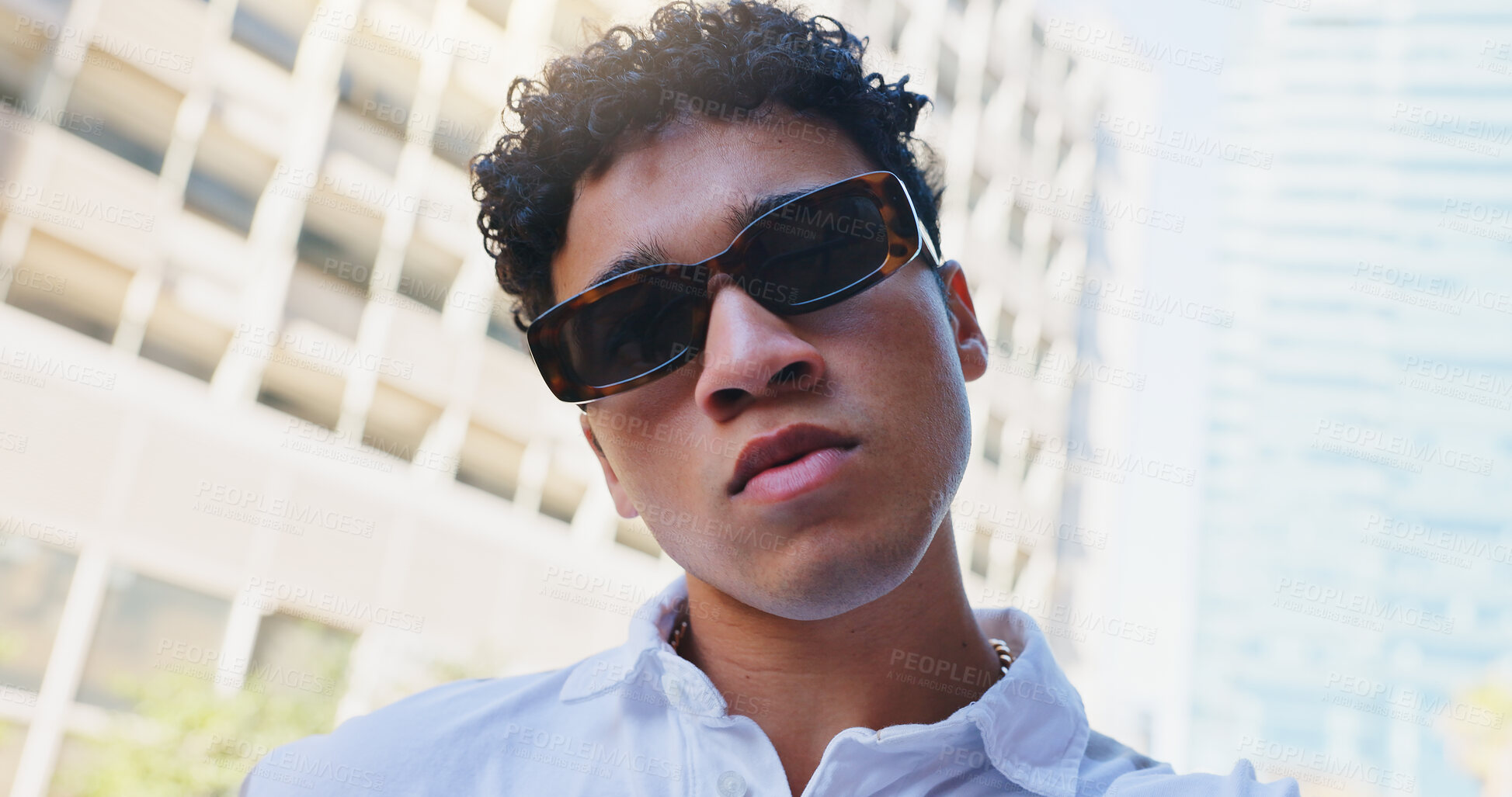 Buy stock photo Portrait, fashion and man in city, sunglasses and urban town with trendy clothes, style and sunshine. New York, face and guy with funky eyewear, gen z and casual outfit with buildings and confidence