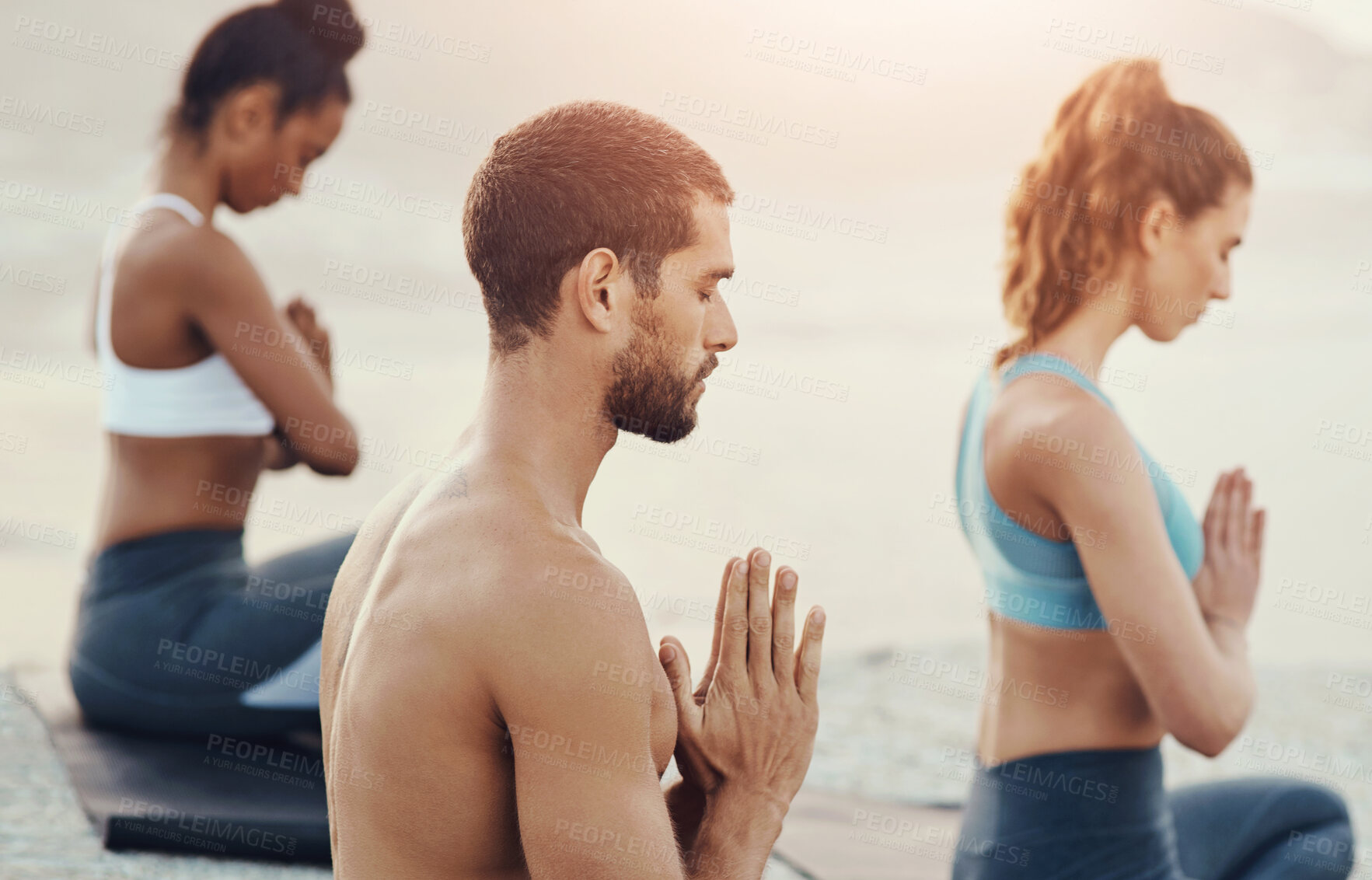 Buy stock photo Yoga, meditation and people with prayer on beach for wellness, workout and mindfulness in nature. Pilates, mental health and men and women in praying pose for meditation, peace or spiritual awareness