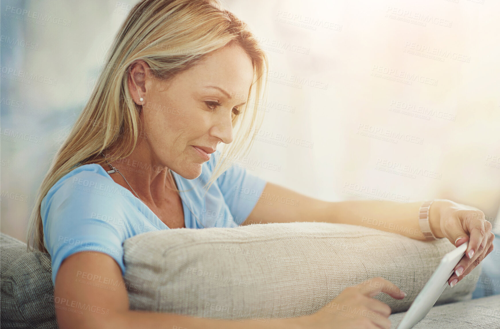 Buy stock photo Mature, woman and tablet with relax on sofa for internet browsing, social media app or online subscription. Person, smile and digital technology on couch in living room for reading ebook or blog post