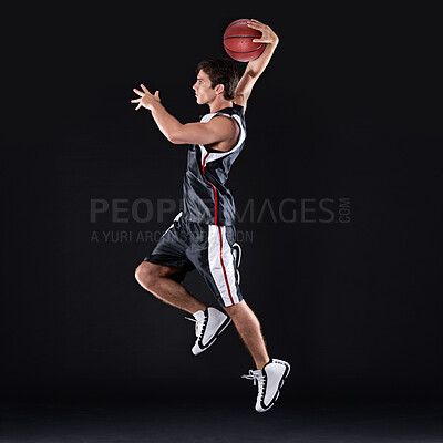 Buy stock photo Basketball, training and man jump in studio for exercise, energy and healthy body fitness. Sports, player and athlete shooting ball for competition, game and mockup space isolated on black background