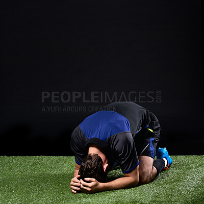 Buy stock photo Field, soccer player and man in grass, fail and frustrated in game, stress and upset on ground in studio. Black background, sad and athlete with depression, unhappy and person with loss in football