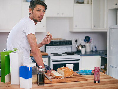 Buy stock photo Man, portrait and eating with breakfast in kitchen for morning meal, snack or food at home. Young male person with sandwich, bread or wheat for healthy nutrition, fiber or start of day at house