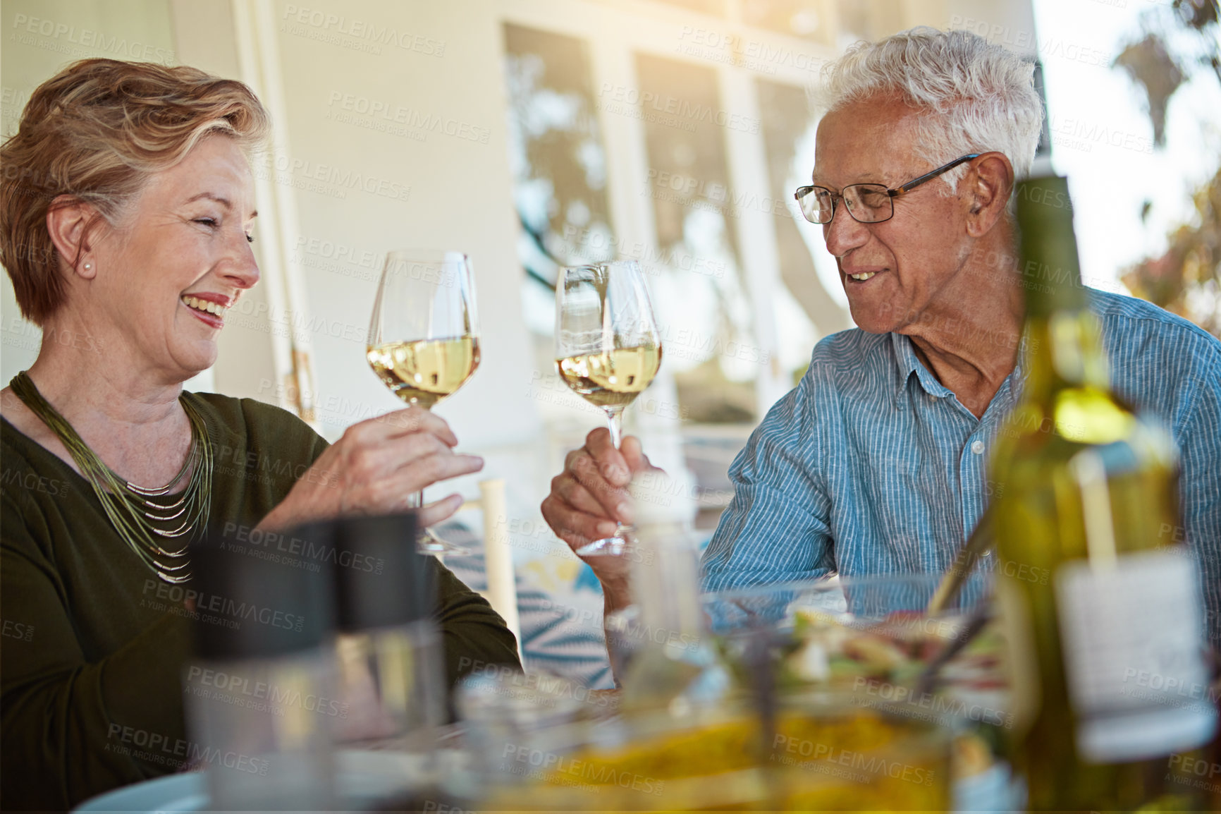 Buy stock photo Love, celebration and senior couple with wine toast on patio for anniversary, event or birthday party brunch. Food, happy and old people at an outdoor restaurant with retirement, cheers or bonding