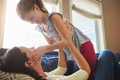 Buy stock photo Love, smile and mother hugging her child while relaxing on sofa in the living room of their home. Happiness, bonding and young mom embracing and her laughing daughter with care in their family house