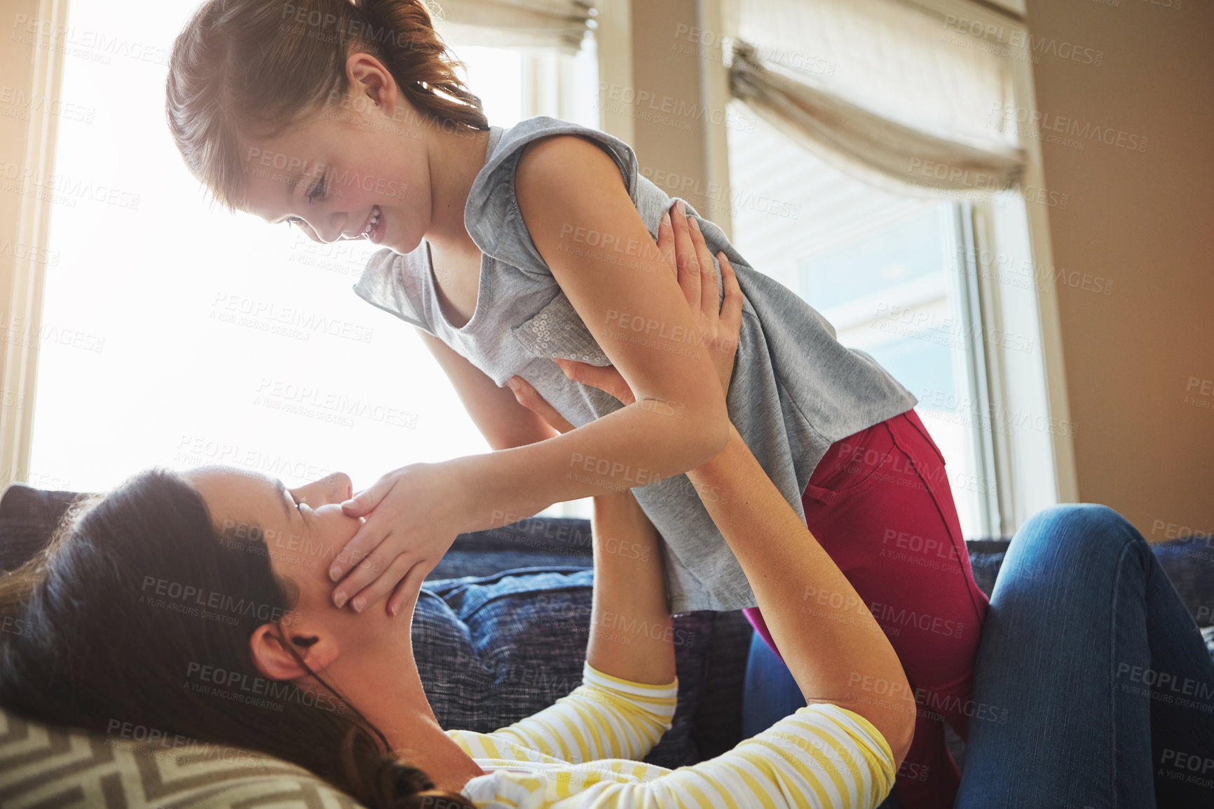 Buy stock photo Love, smile and mother hugging her child while relaxing on sofa in the living room of their home. Happiness, bonding and young mom embracing and her laughing daughter with care in their family house