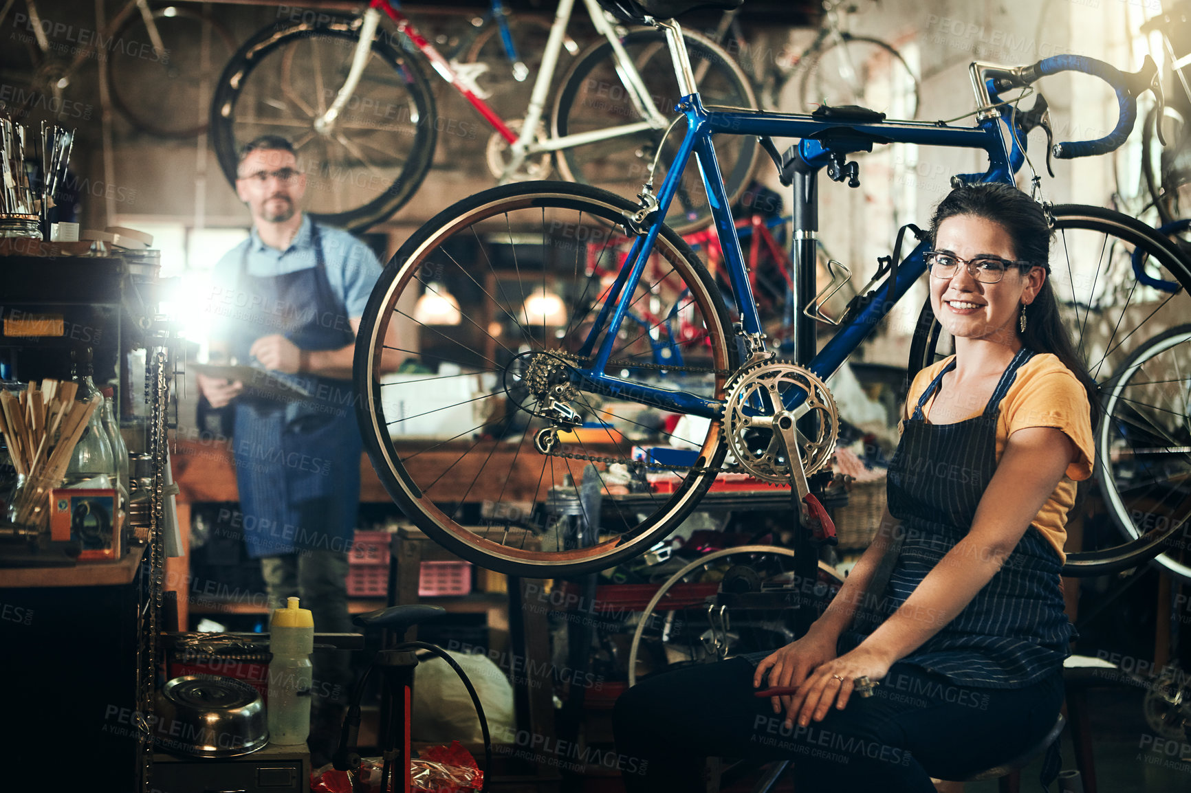 Buy stock photo Woman, portrait and smile at work in bicycle repair shop or maintenance garage. Bike, mechanic and service with a professional handyman coworker for startup, small business and workshop for fixing